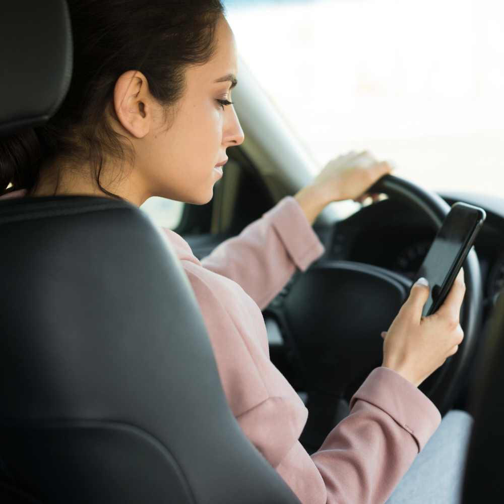Woman Steering Wheel Using Her Phone
